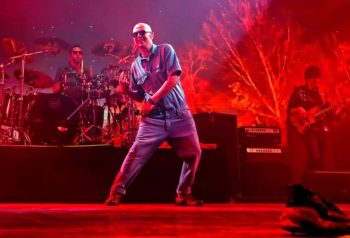 Indio Solari en recital con banda y luces rojas