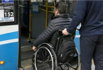 Una persona usuaria de silla de ruedas accede a un colectivo con asistencia