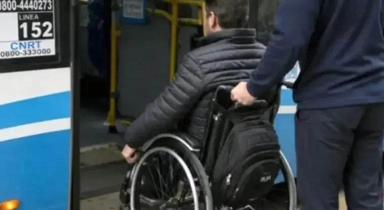 Una persona usuaria de silla de ruedas accede a un colectivo con asistencia