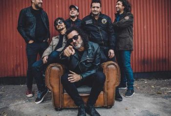 Los Pérez García posan junto a un sillón de cuero frente a una pared roja