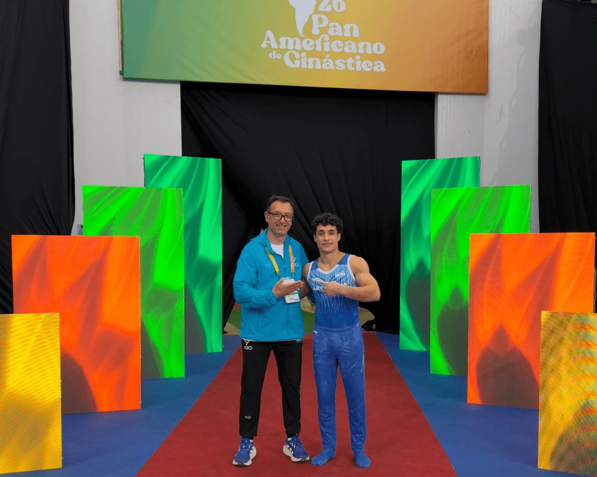 Santiago Mayol con su entrenador en una competencia de gimnasia; fotografía de archivo.