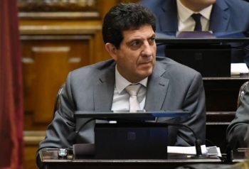 Fernando Rejal sentado en su banca; retrato individual en interior parlamentario.