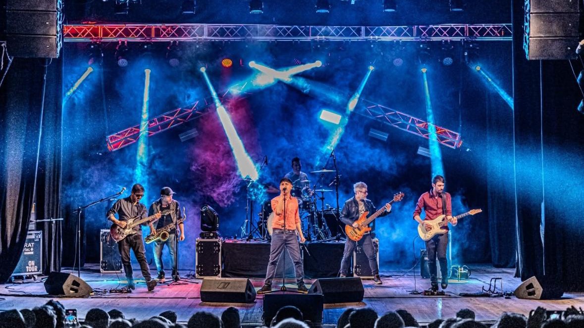 Rey Garufa y sus Timadores en vivo sobre un escenario iluminado